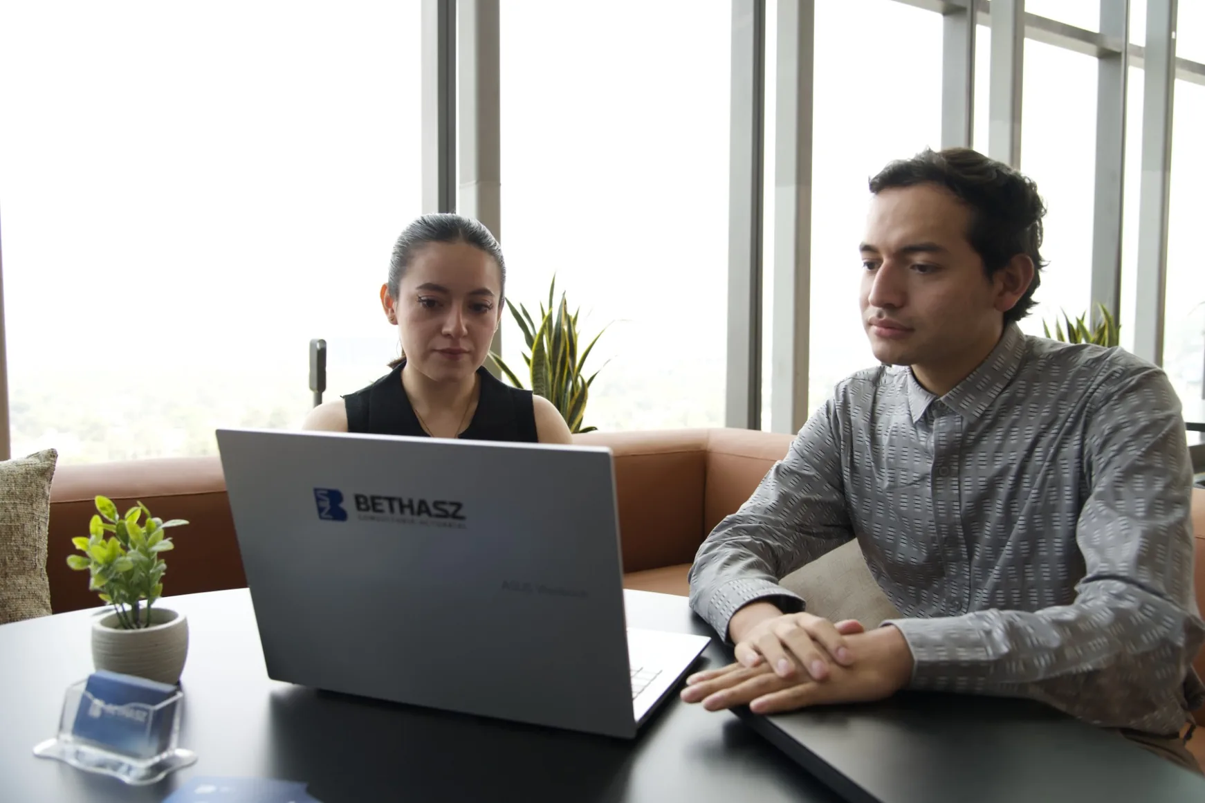 Dos consultores de BethaSZ analizando información financiera frente a una laptop